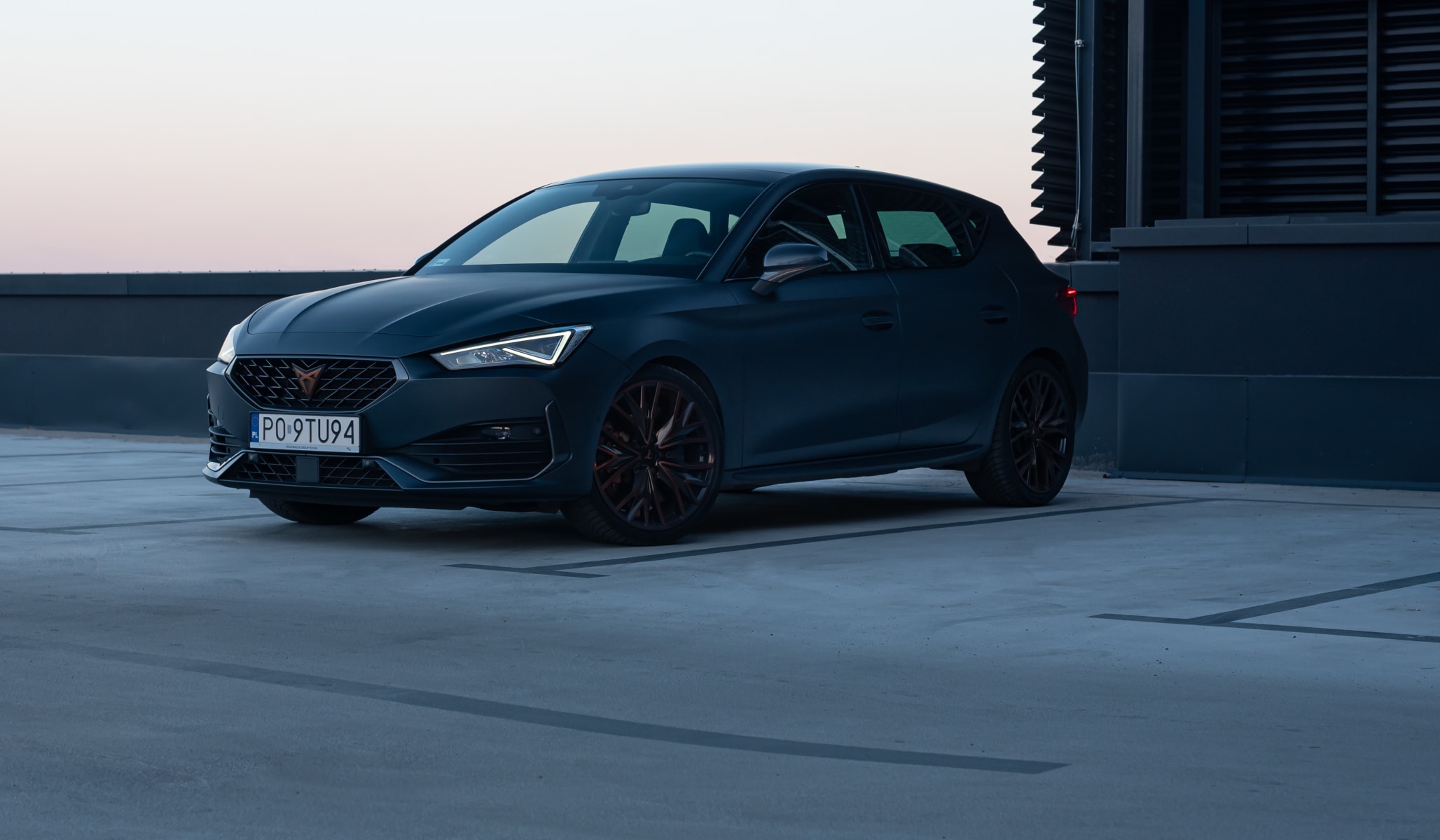 CUPRA Leon na parkingu dachowym. Zbliżenie na przednią część nadwozia CUPRA Leon na parkingu dachowym. Zbliżenie na przednią część nadwozia