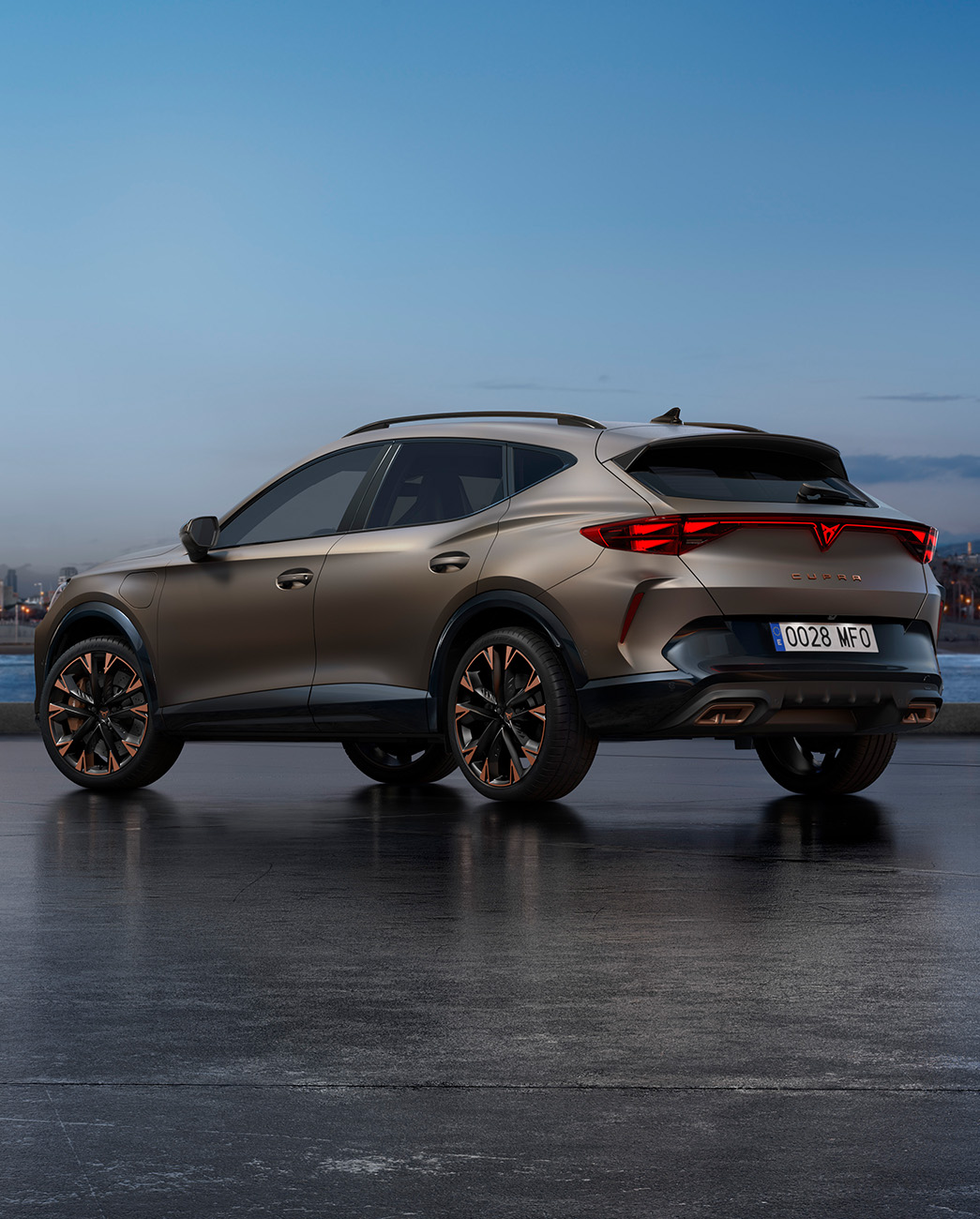 Nowa CUPRA Formentor 2024 w kolorze Century Bronze Matt zaparkowany na nadbrzeżnej promenadzie o zmierzchu. W tle widać krajobraz miasta z drapaczami chmur i palmami oświetlonymi gasnącym światłem dnia.